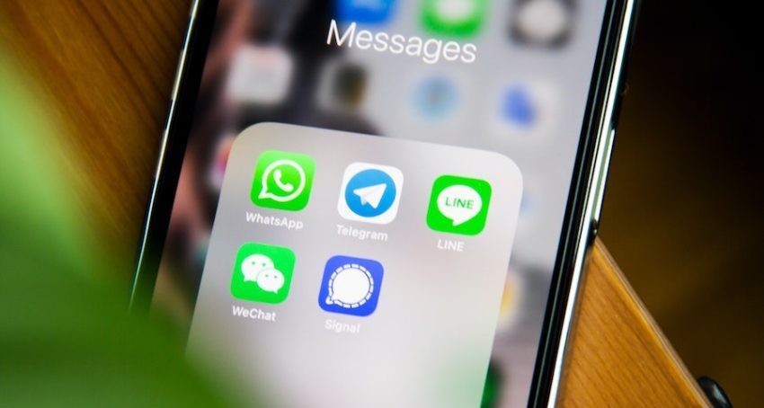The image is of an iPhone screen with a folder containing several text messaging apps.